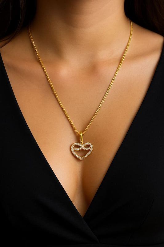 Primer plano de modelo latina con vestido negro luciendo la Cadena Corte Brillo de Oro 10K y el Dije de Corazón Infinito con diamantes, destacando el brillo de la joya en el cuello.